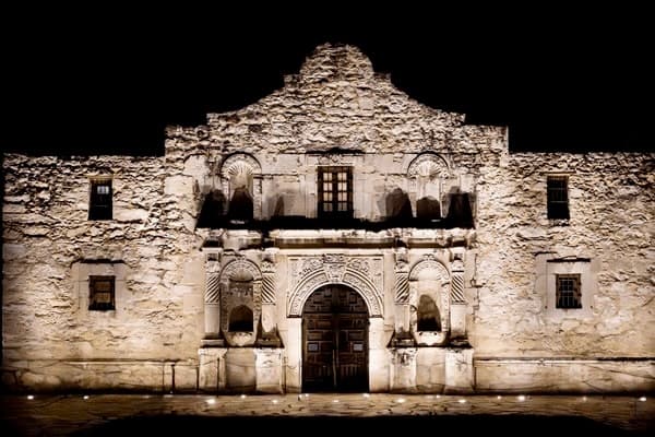 The illuminated Alamo mission facade at night in San Antonio, Texas